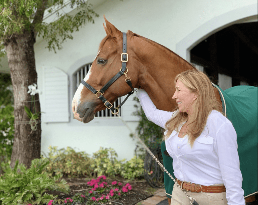 A lady holding her brown horse